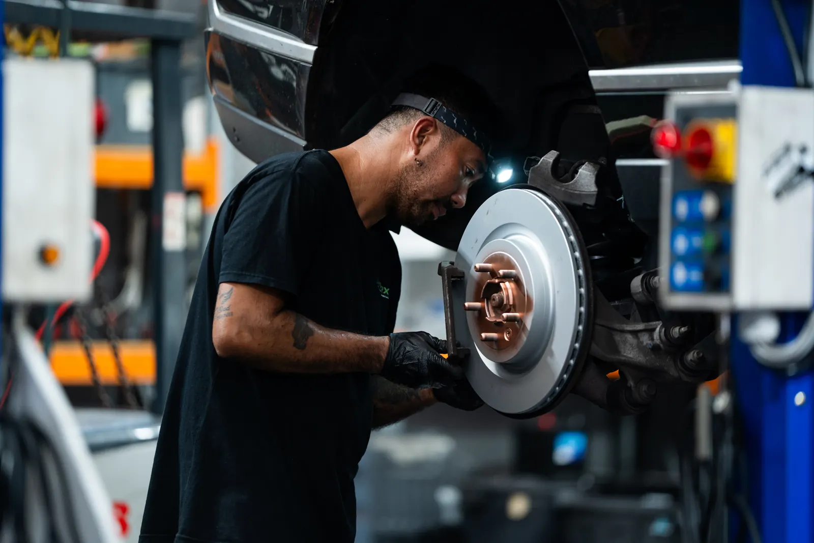 RoverX technician inspecting Range Rover brake disc in Kirrawee workshop