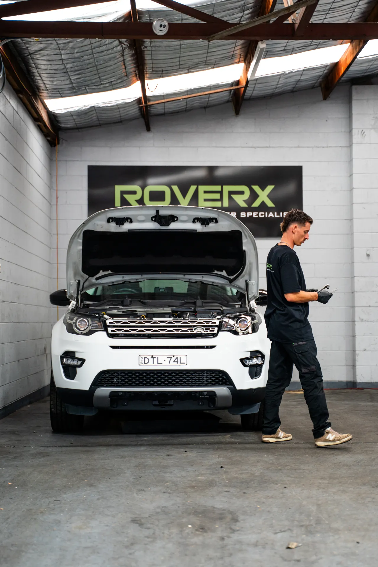 RoverX technicians working on a Land Rover Discovery on the hoist
